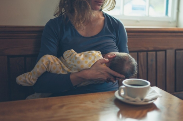 Mother breastfeeding infant at business