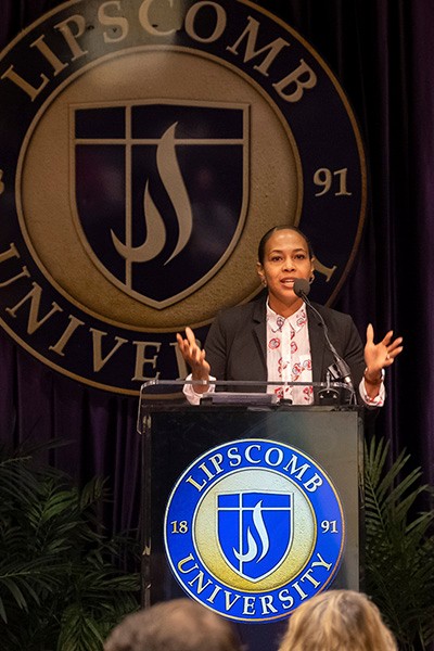 DSCF0414-2 Dr. DeAndria Witherspoon-Nash speaks at the first-ever Collegiate Recovery Academy at Lipscomb University behind a podium. The Lipscomb University seal is on the podium and behind the speaker