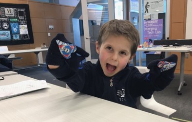Hugh mittens A young boy holds up his hands, which are wearing Star Wars mittens, and his face has a big goofy smile