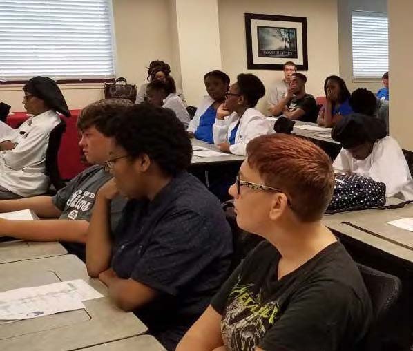 group photo of a class of students learning and listening.