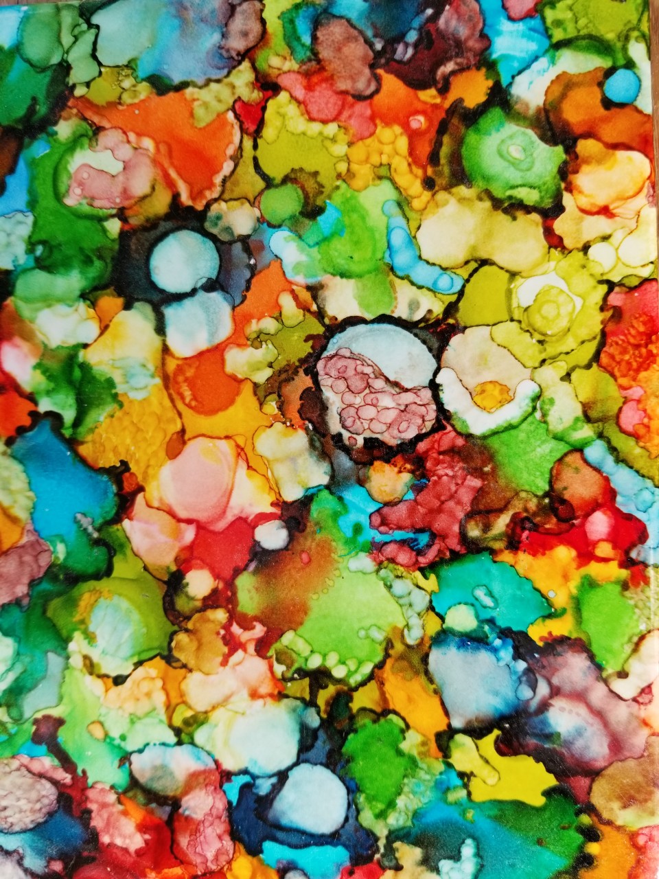 An abstract piece that shows watery splotches of varying sizes and colors and shapes overlapping with each other. It almost looks like a kaleidoscope image.