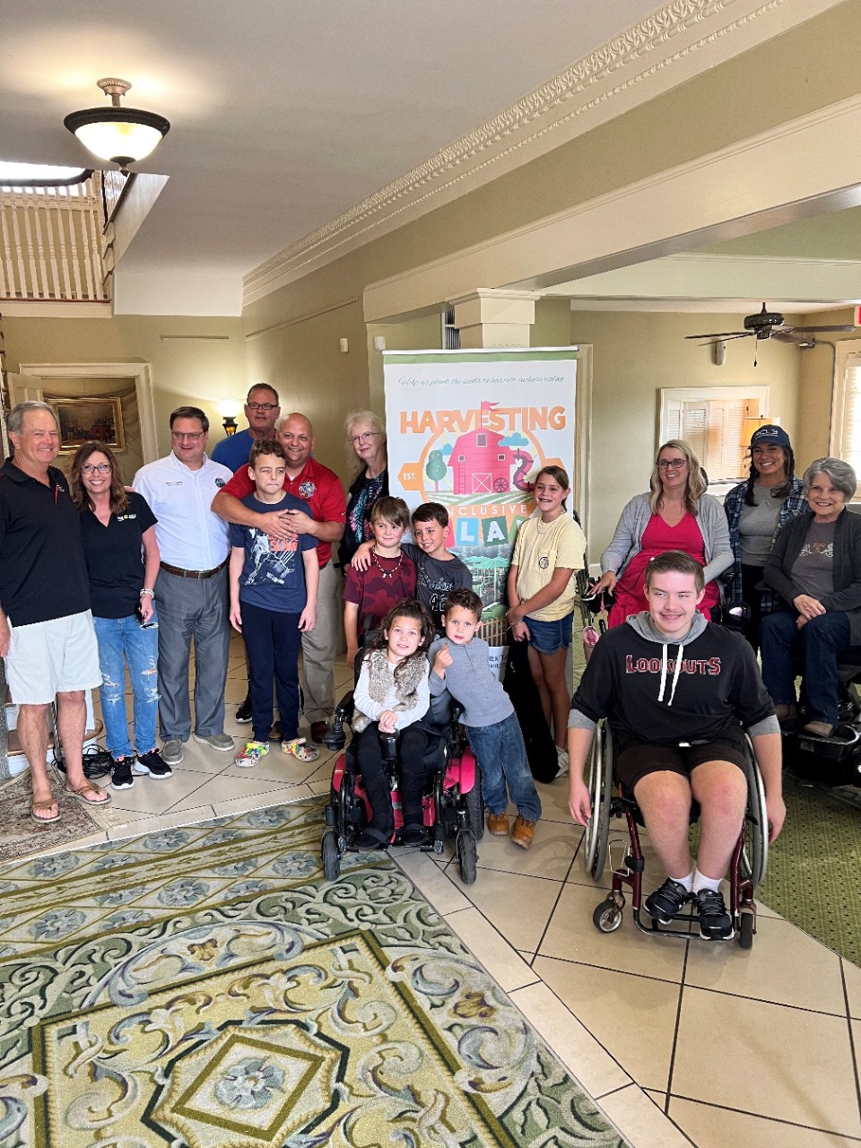 Nov. 2022 kick-off event for Harvesting Inclusive Play a large group of children and adults, many with visible disabilities, gather around a banner for the Harvesting Inclusive play project