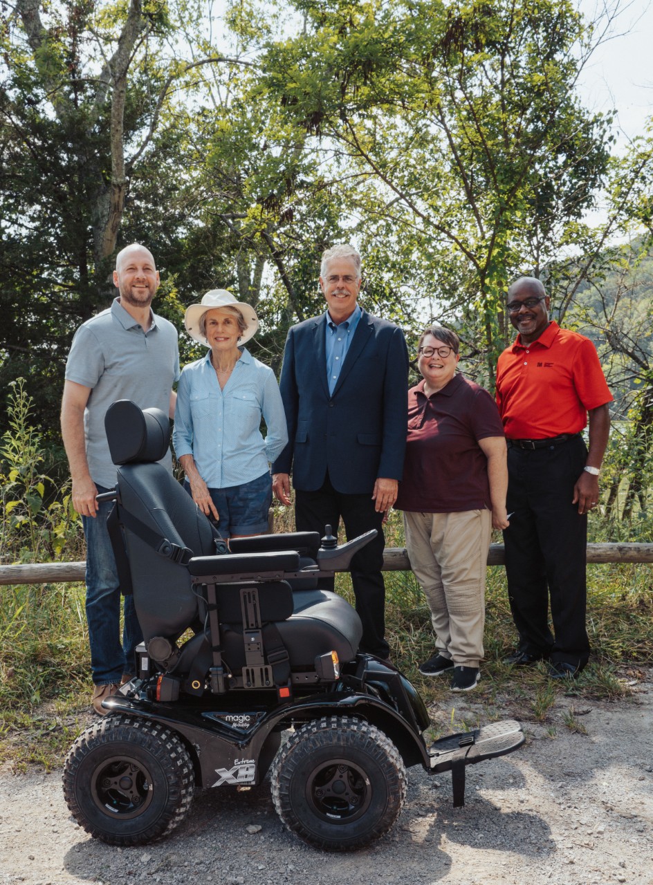 An August 29 event at Radnor Lake State Park celebrated a TVA grant to support accessibility in State Parks a group of people stand in front of the all-terrain wheelchair in an outdoor photo.