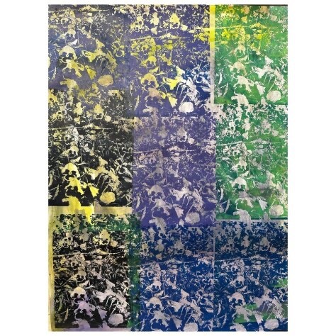 A rectangular piece of paper is stamped with a silvery-white repeating, vaguely floral pattern. The pattern is laid over blocks of color – blue, green, violet and black. Subtle streaks of yellow or green overlay the pattern. 