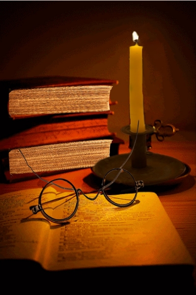 Franklin (Named after Benjamin Franklin) - Sami Zinni An open book with aged pages rests on a wooden surface, with a pair of round spectacles placed atop it, evoking a sense of deep study or contemplation. A tall, flickering candle in a brass holder casts a golden glow, illuminating a stack of old, well-worn books in the background.