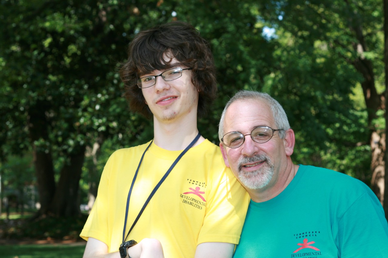 Ned photo Ned in a bright green Council t-shirt and a young man with a disability who was in a past Council youth leadership training