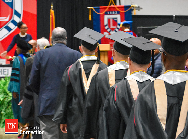 Photo of the Back of Four Offenders Walking Into Graduation