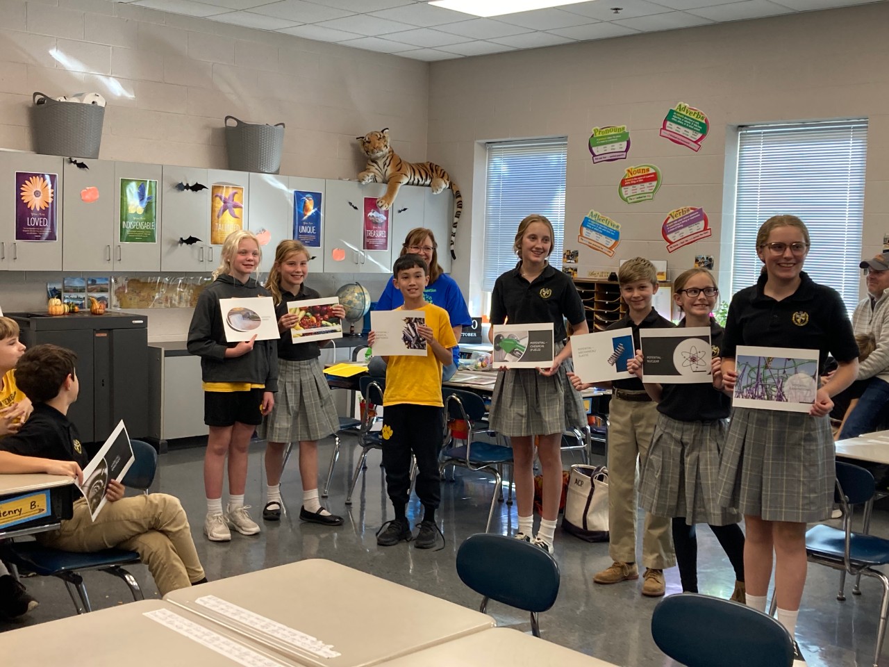 children holding up printed slide show slides during classroom activity