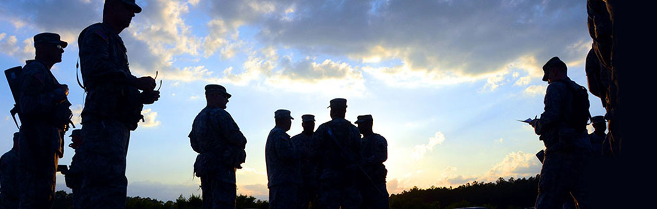 Silhouettes of Soldiers are gathered around meeting with each other against a blue sky with clouds and sunrise background.