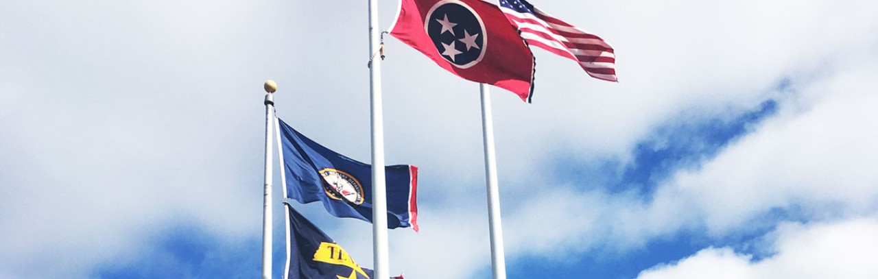 Flags wave in front of Joint Force Headquarters in Nashville, Tenn. Flags shown are the American Flag, State of Tennessee Flag, Tennessee Military Department Flag, and the Tennessee Emergency Management Agency Flag.