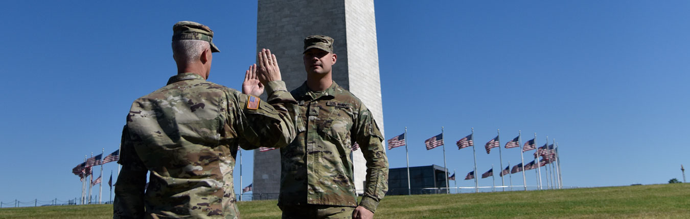 Soldiers with hand raised during reenlistment ceremony