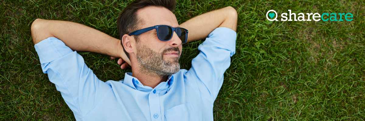 Man wearing sunglasses lying on the grass