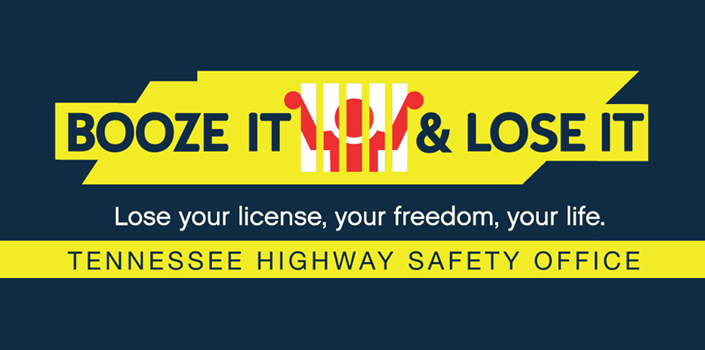 A dark blue banner with a yellow graphic that reads “BOOZE IT & LOSE IT.” The word “IT” is stylized as a red figure behind white jail bars. Below the main slogan is the line “Lose your license, your freedom, your life.” At the bottom, a yellow strip displays the text “Tennessee Highway Safety Office.”