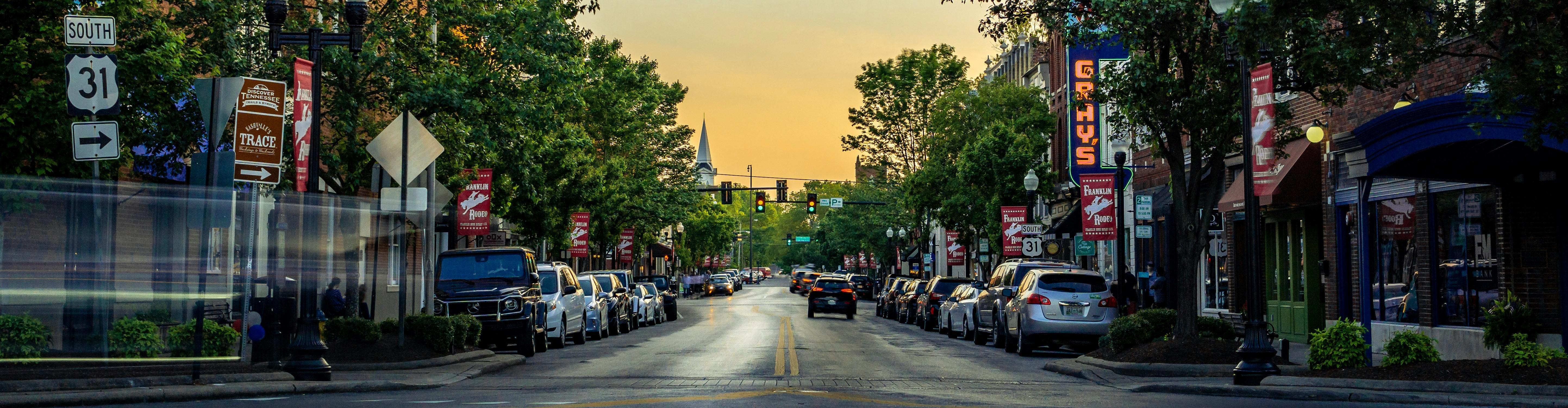 Photo of city street with many small businesses at sunrise