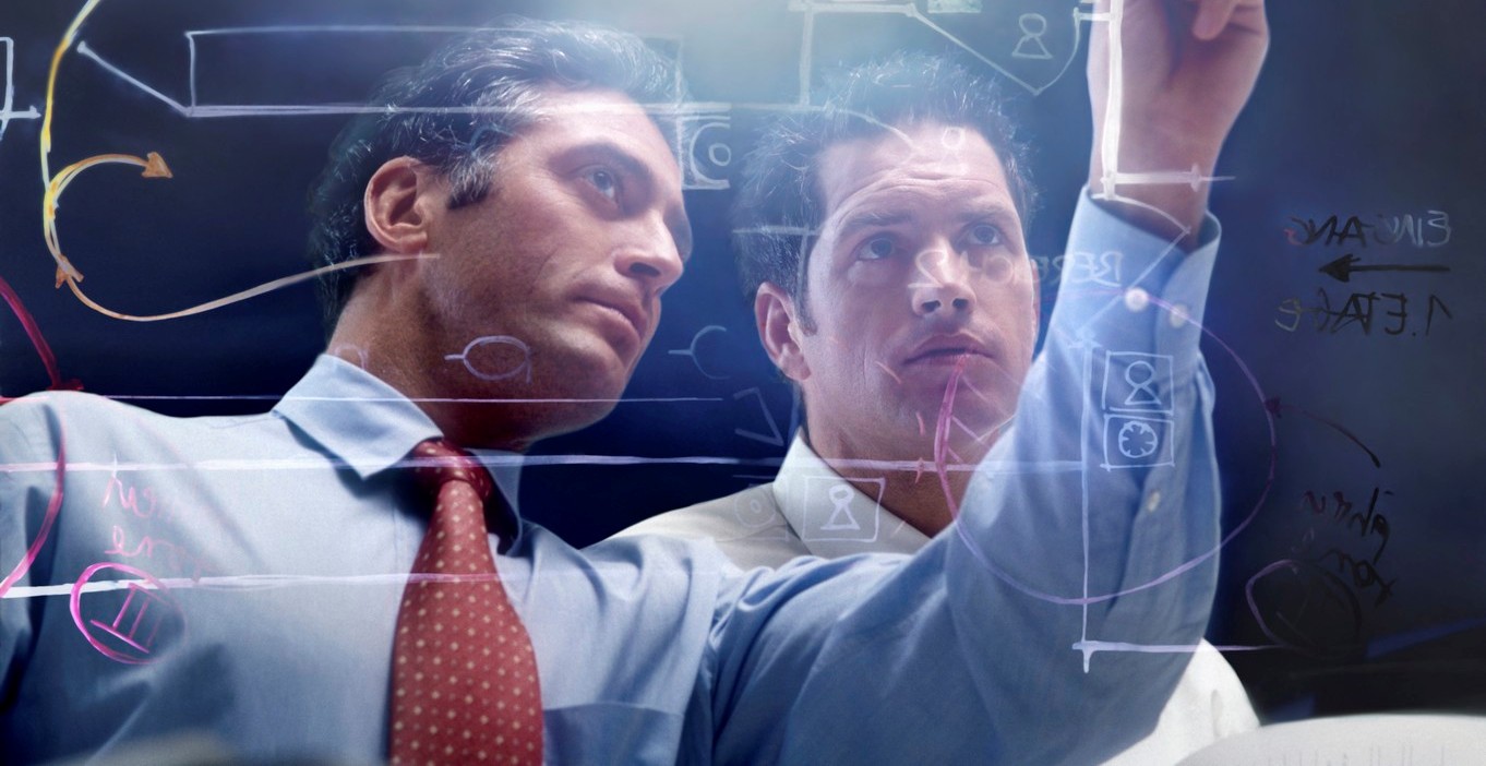 Two men look at a screen with images on it