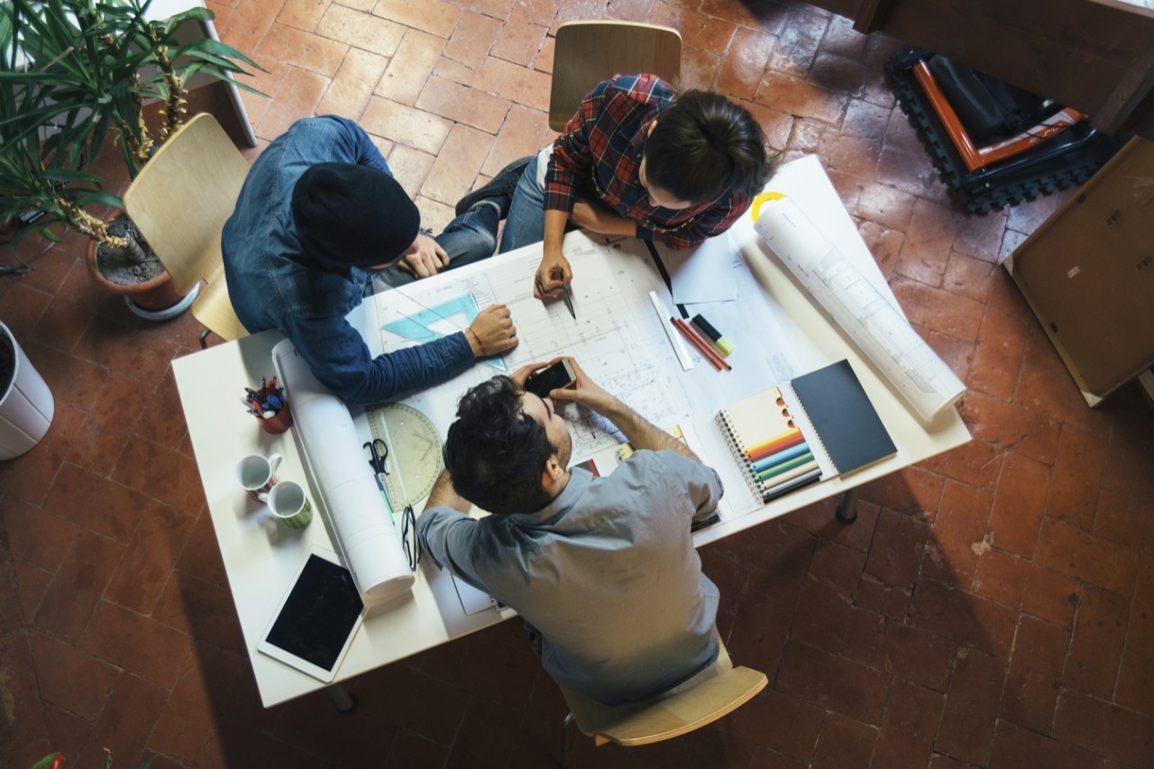 Overhead view of two people looking over documents