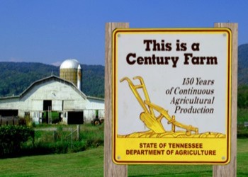 A sign on a fence indicating that the farm behind it is a Century Farm