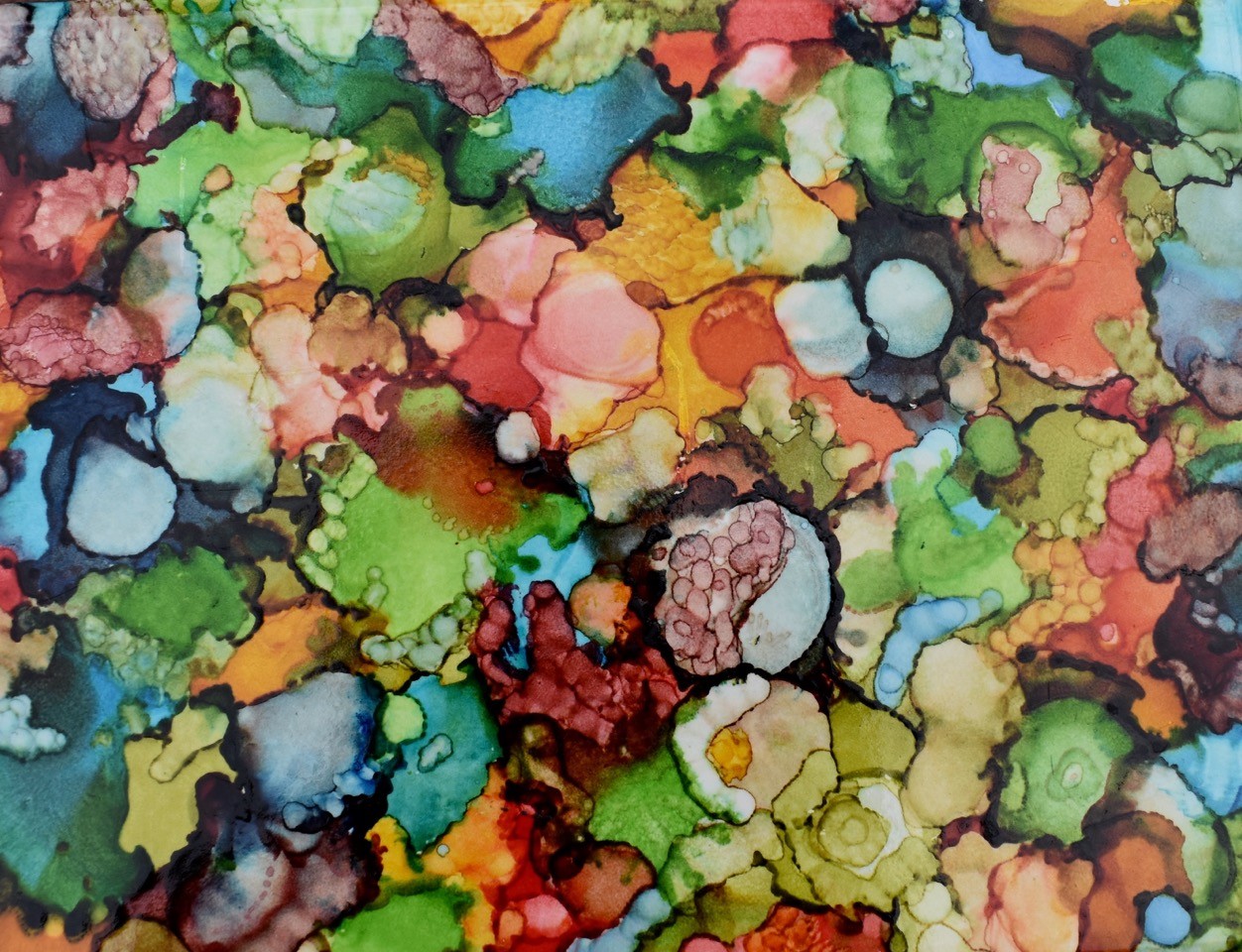 A watercolor painting with watery blotches of all colors all over the canvas; it reminds a viewer of liquid on a slide under microscopes – round shapes all overlapping and all types of colors.