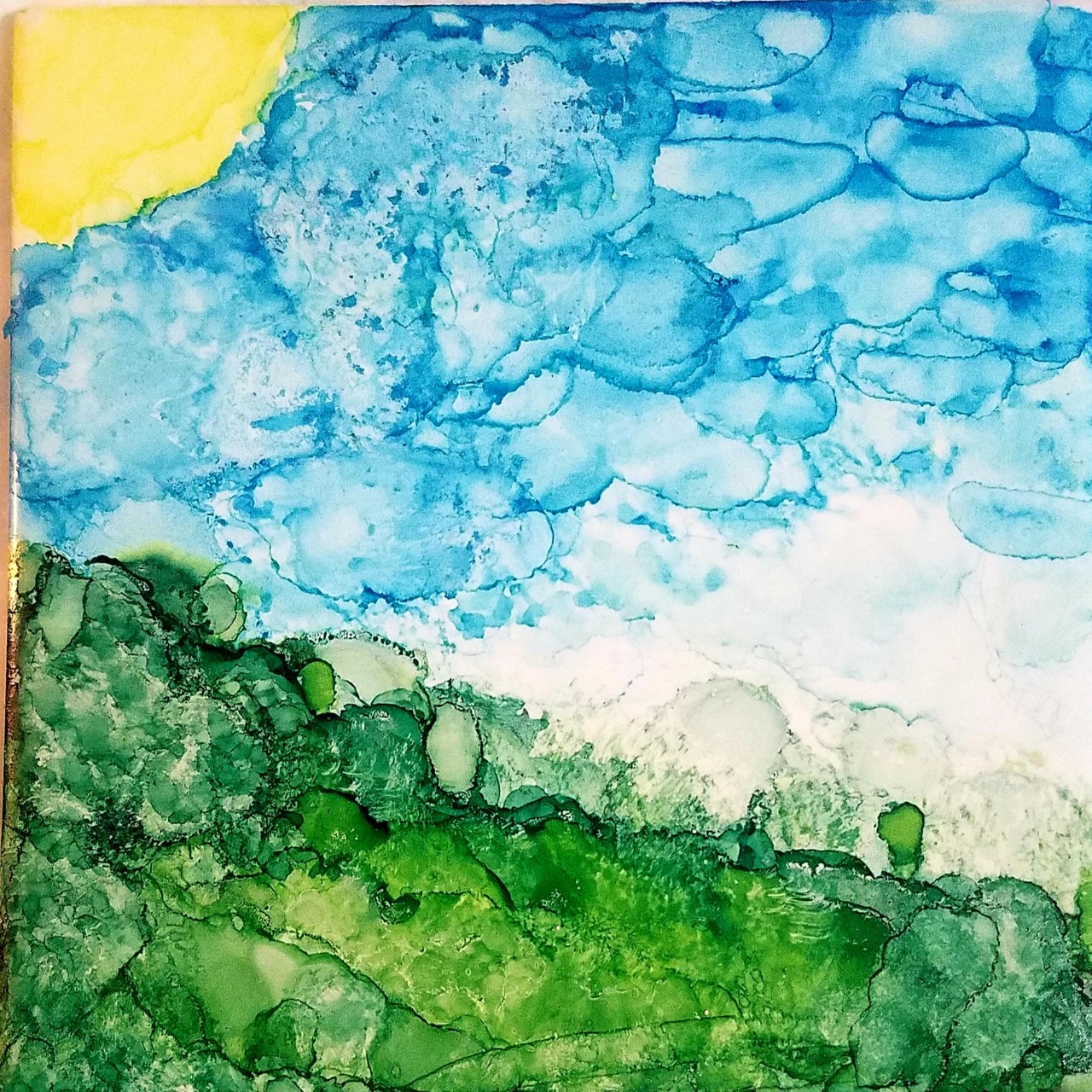 A sunny, bright, watercolor painting of a blue sky and bright green grass and pale yellow sun. The painting is done in splotches, meant to look like a watercolor and not very realistic.