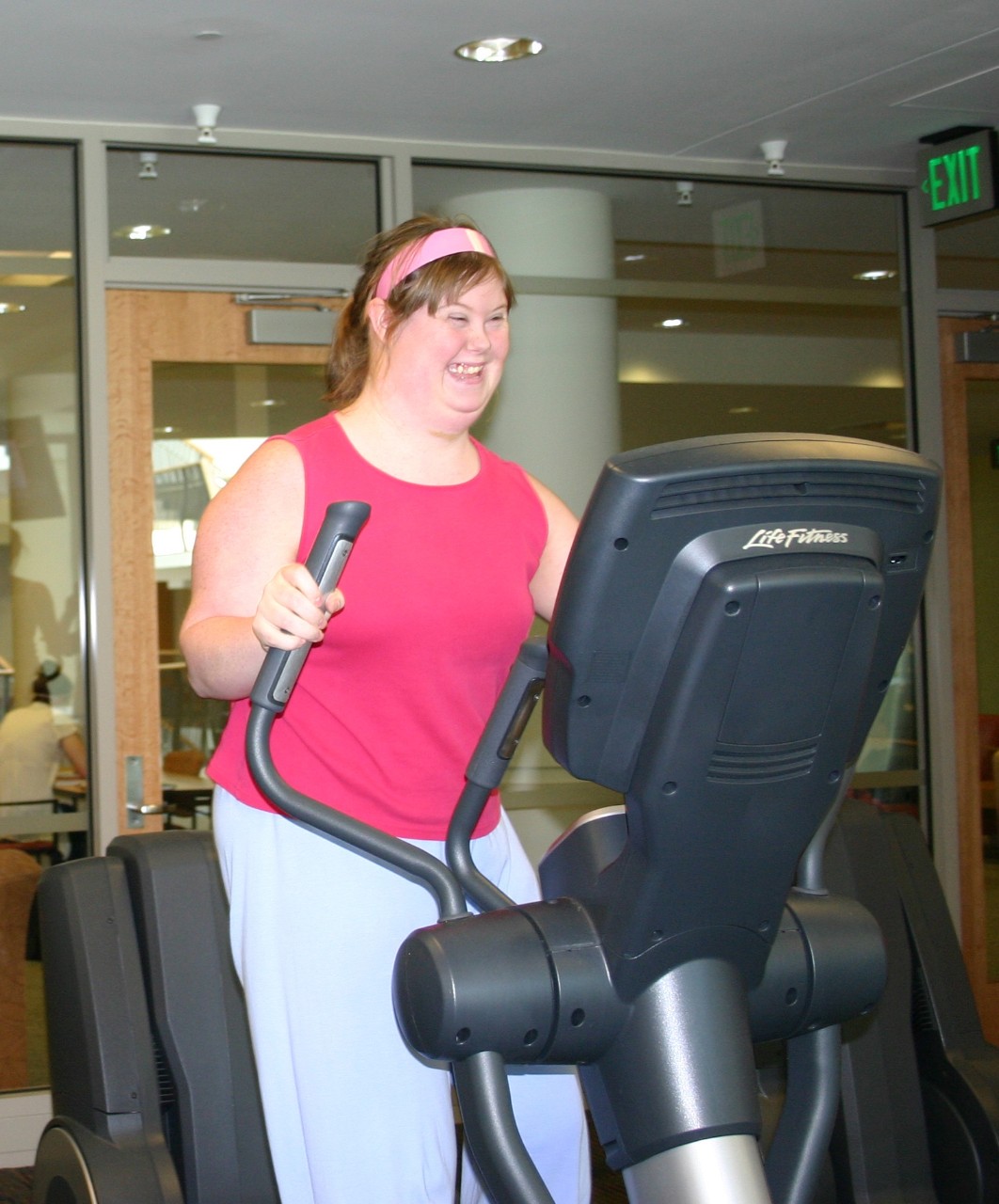 Jeanne Gavigan when she was at Next Steps, smiling and in bright pink workout clothes on a treadmill