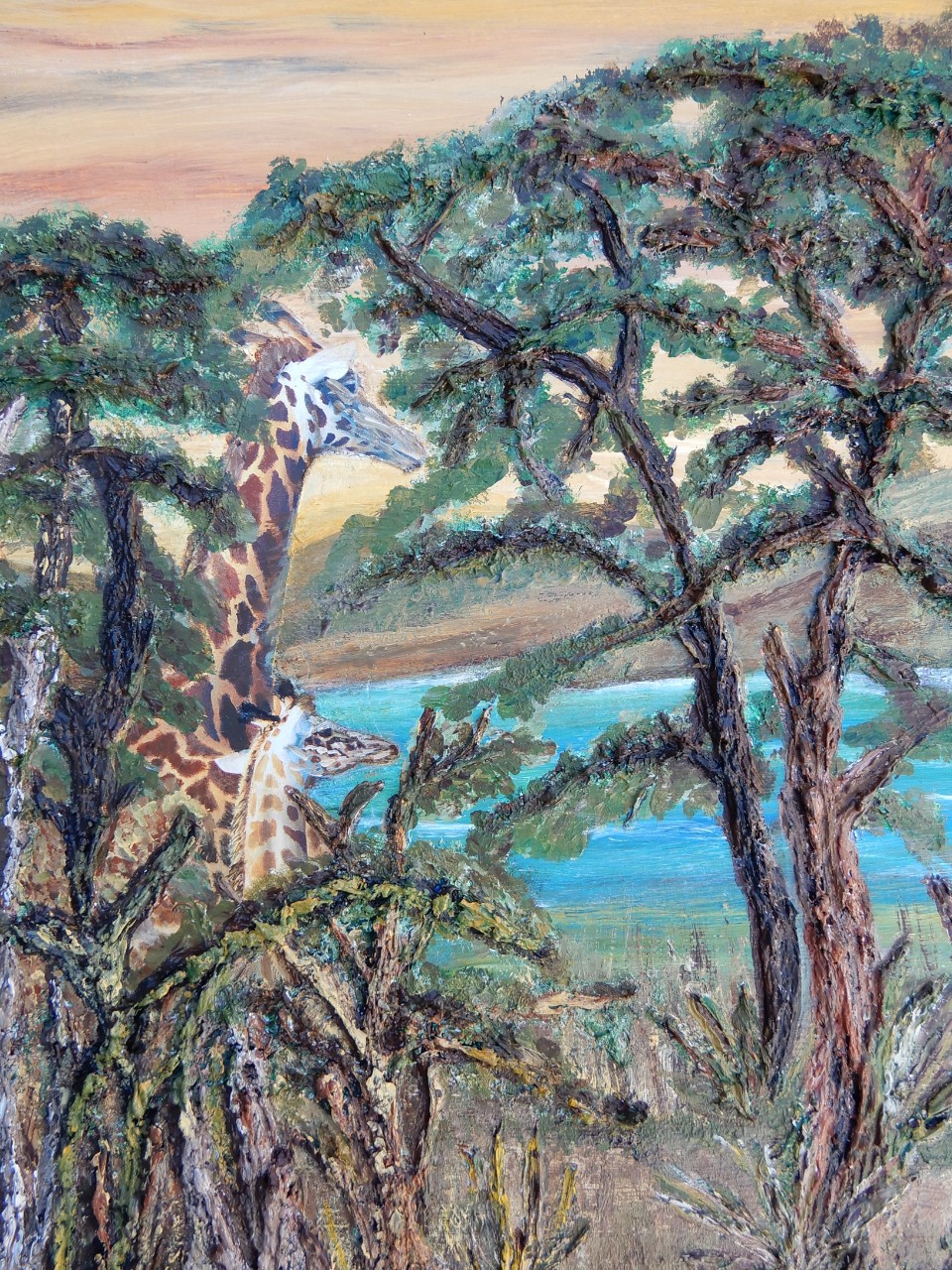 Painting shows a full grown giraffe and a smaller younger giraffe standing side by side amongst some trees in front of a small body of water.