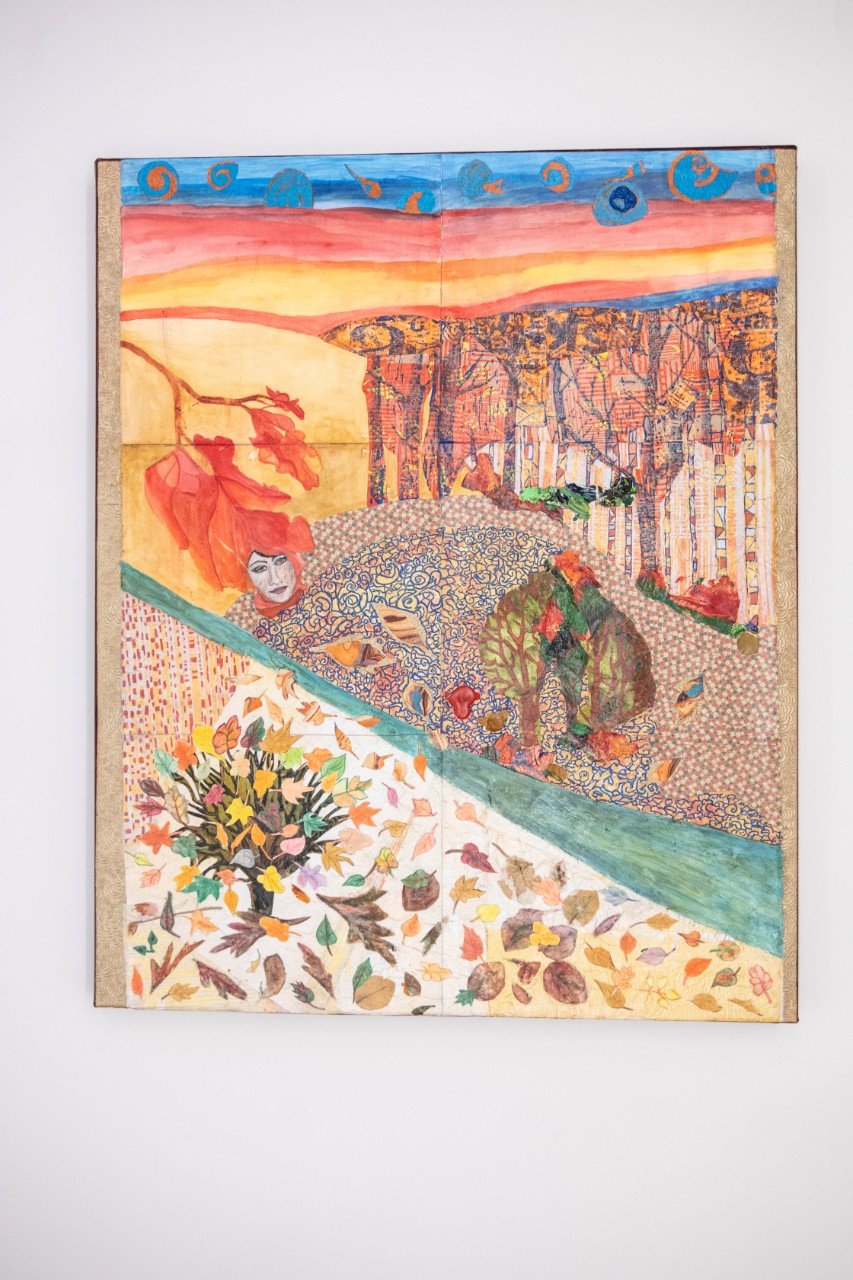 a mixed media piece showing a nature scene of a river cutting across the canvas with leaves, trees and forests on either side; there are different patterns on the canvas and many autumn colors