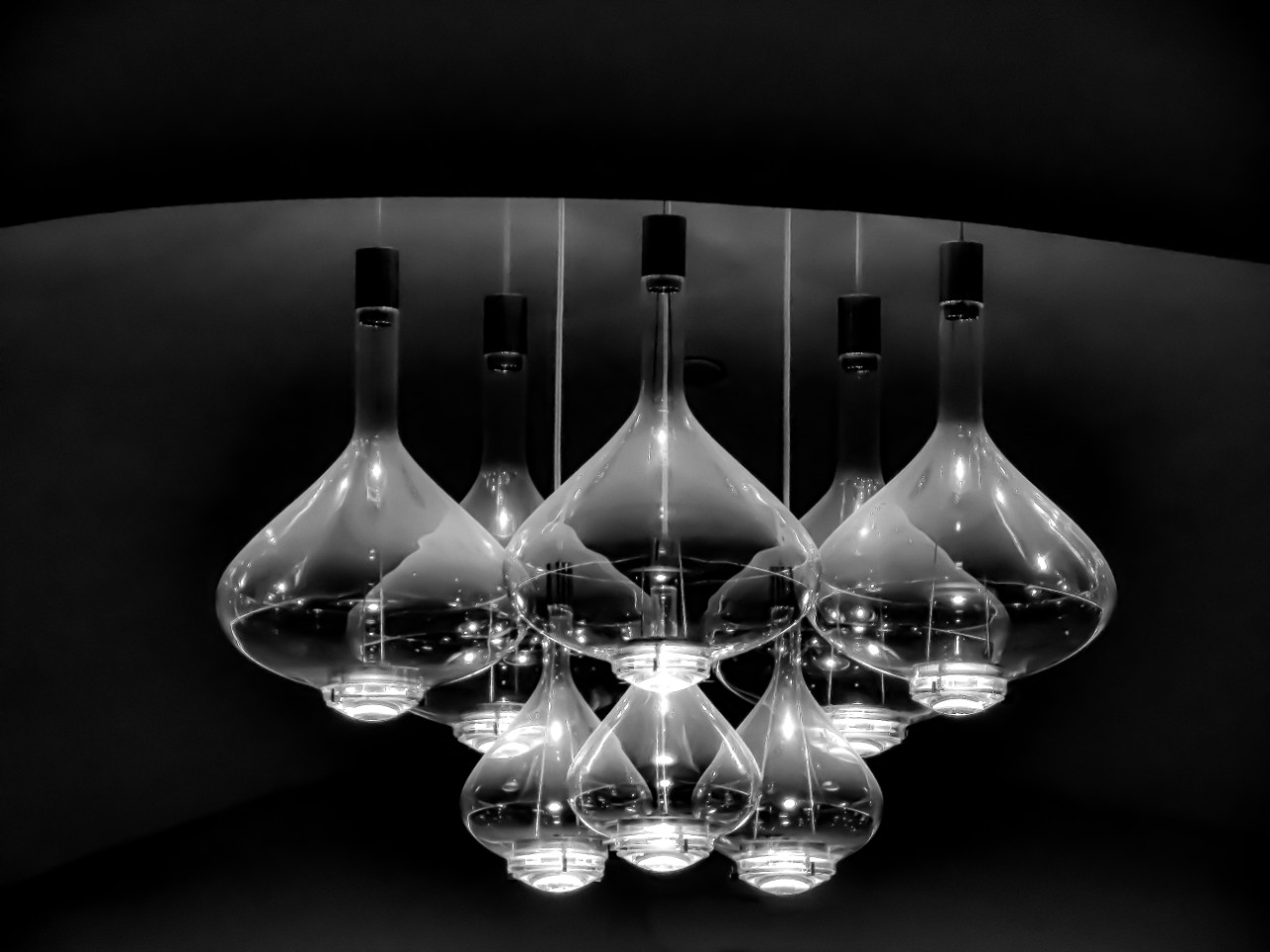 a dramatic black and white close-up photo of a cluster of chandelier teardrop lights