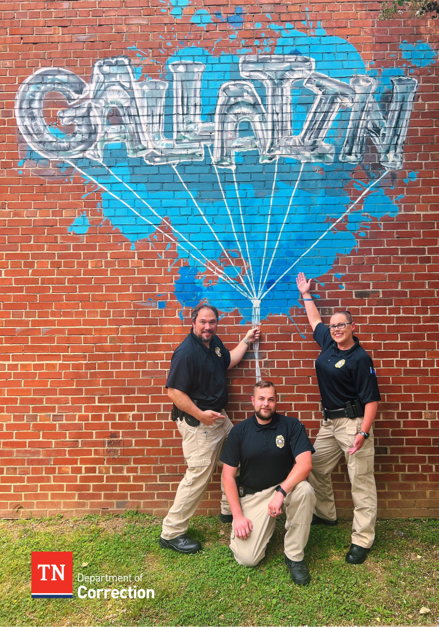 Photo of probation parole officers with Gallatin mural