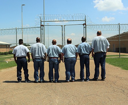 Photo of Offenders Standing in Front of Gate