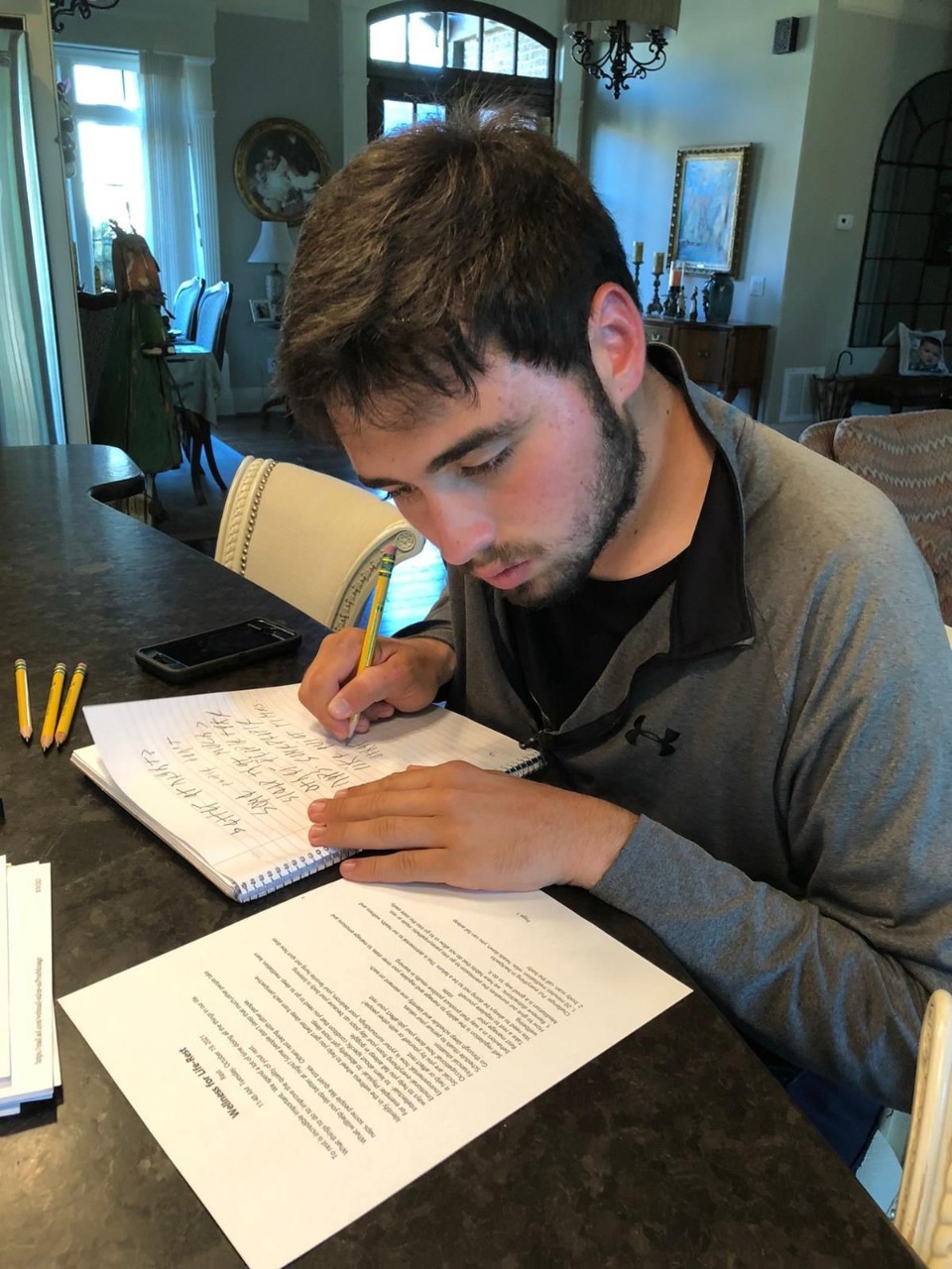 A man sitting at a counter working on homework