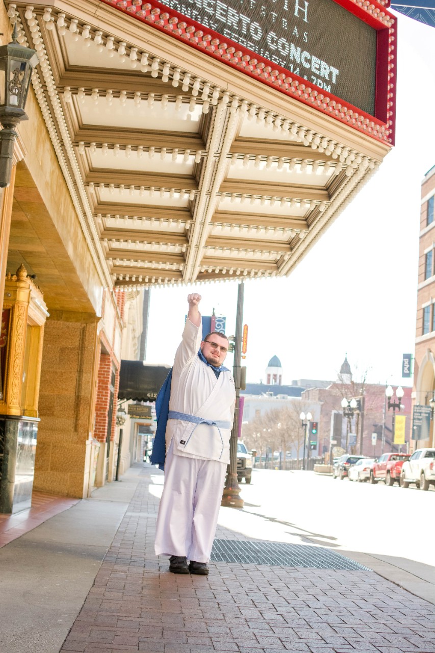 JacobOutsideTNTheater Jacob wearing his super jacob costume and in a super hero pose underneath the Tennessee theatre sign