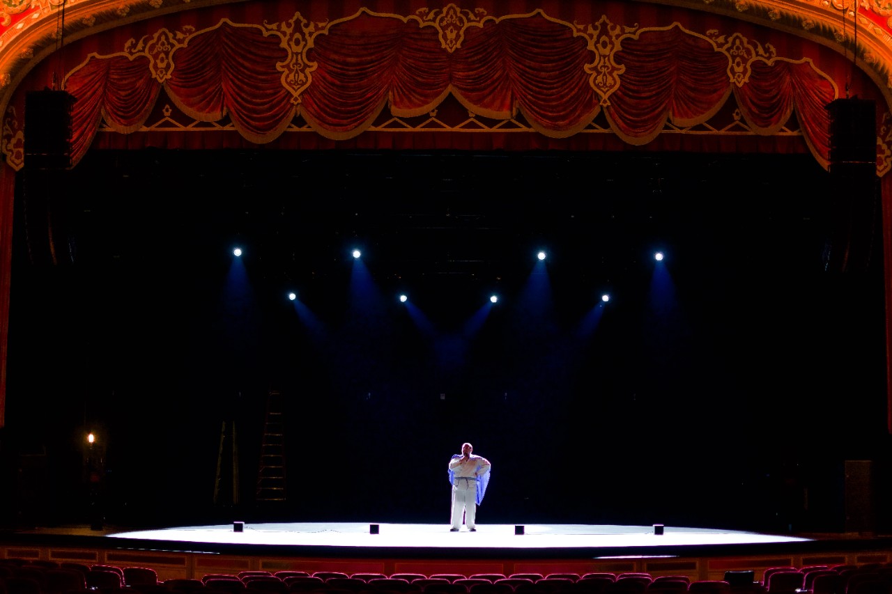 DSC_4716 Wide shot of super jacob standing on stage with lights all around him