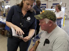Hixon, TN, June 2, 2011 -- Emily Torres, a FEMA mitigation advisor, explains information in a brochure to a disaster survivor. FEMA personnel provide a large variety of mitiagation services with displays at local stores such as Home Depot. Photo by EdEdahl/FEMA. 