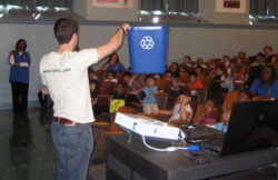 photo of blue recycling bin demonstration to students