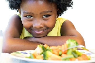little girl with plate of veggies