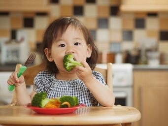 Toddler eating broccoli