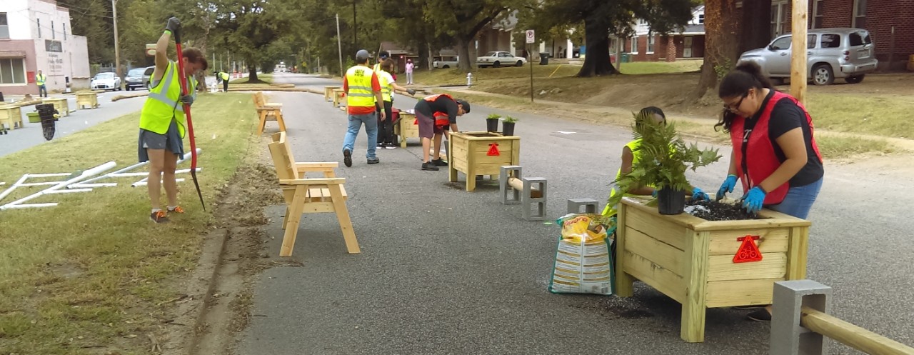 Community members installing wooden benches and garden beds on National Street