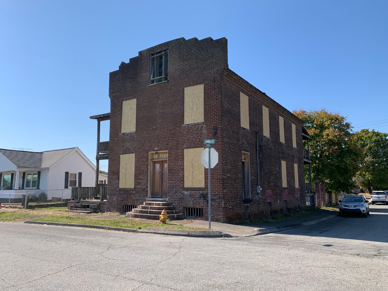 Image of a brown brick building with windows boarded up