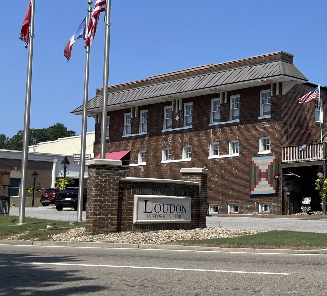 Image of the Loudon Historic District sign with a brick building in the background