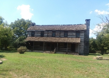 Image of a two-story log home with a long porch