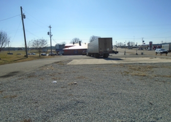 Image of a gravel driveway with a semi truck parked on it.