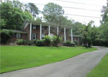 Image of a brown brick house with white columns