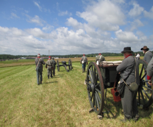Image of Civil War soldiers reenacting in a field with cannons Parker's Crossroads