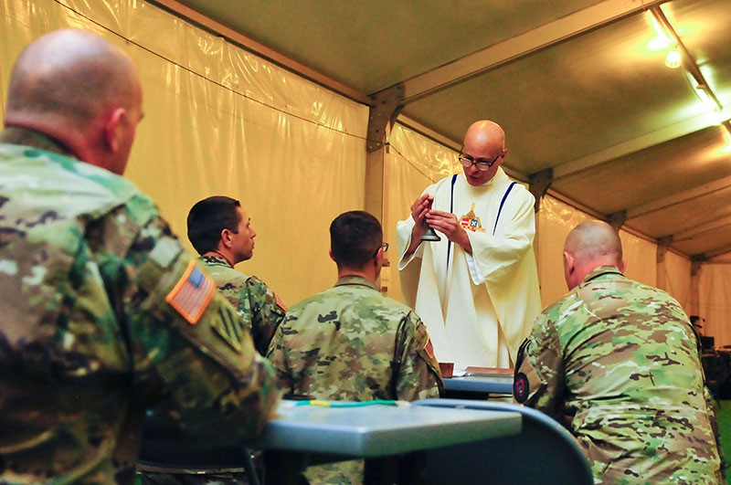 Maj. Patrick Brownell, Brigade Chaplain for the 230th Sustainment Brigade, Tennessee Army National Guard, administers a Catholic service to Soldiers training at the National Training Center, Fort Irwin, Calif. on May 6. Maj. Patrick Brownell, Brigade Chaplain for the 230th Sustainment Brigade, Tennessee Army National Guard, administers a Catholic service to Soldiers training at the National Training Center, Fort Irwin, Calif. on May 6.