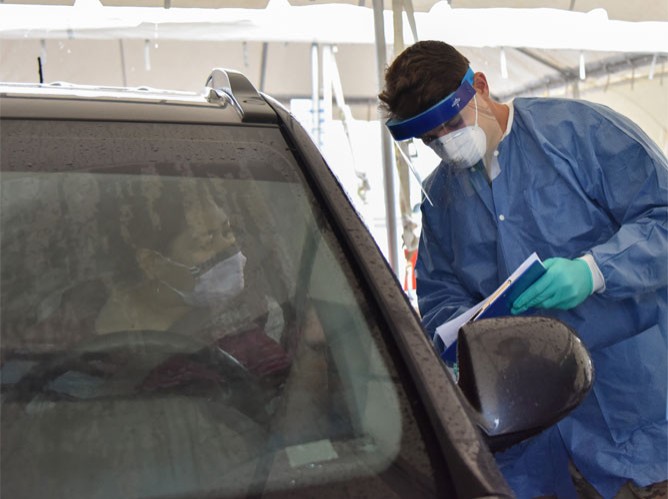 Tennessee Guardsmen in PPE testing a citizen in a drive-thru COVID-19 testing site