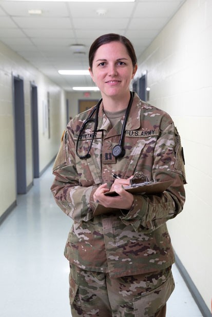 Female Solder holding a clipboard with a stethoscope around her neck