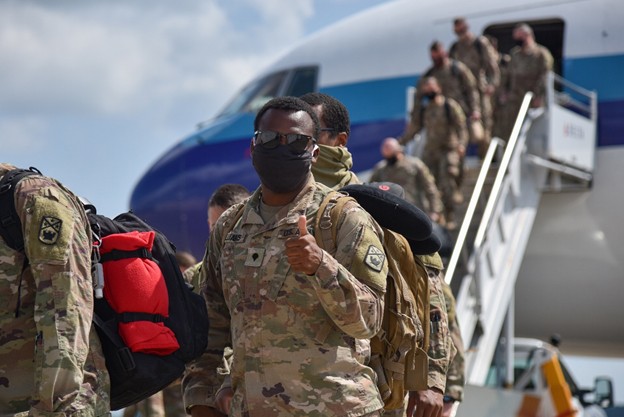 Soldiers coming off of a plane as they return from deployment