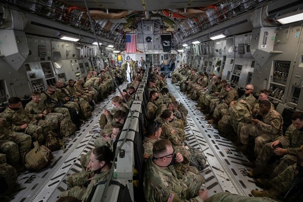 Soldiers inside of a large plane waiting to take off