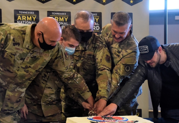 Chief Master Sgt. Kenneth Simmons, Spc. Dakota Richardson, Master Sgt. Anderson Young, Maj. Gen. Jeff Holmes, and Columbia Nashville Recording Artist Kameron Marlowe use a ceremonial saber to cut a cake celebrating the National Guard’s 385th birthday at Smyrna’s Volunteer Training Site, Dec. 13. (Photo by retired Sgt. 1st Class Edgar Castro)