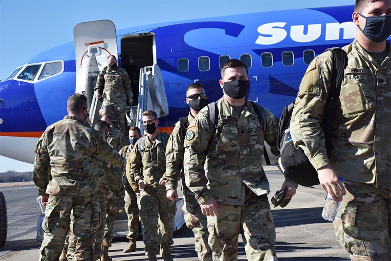 Tennessee National Guard Soldiers coming of of a plane on runway